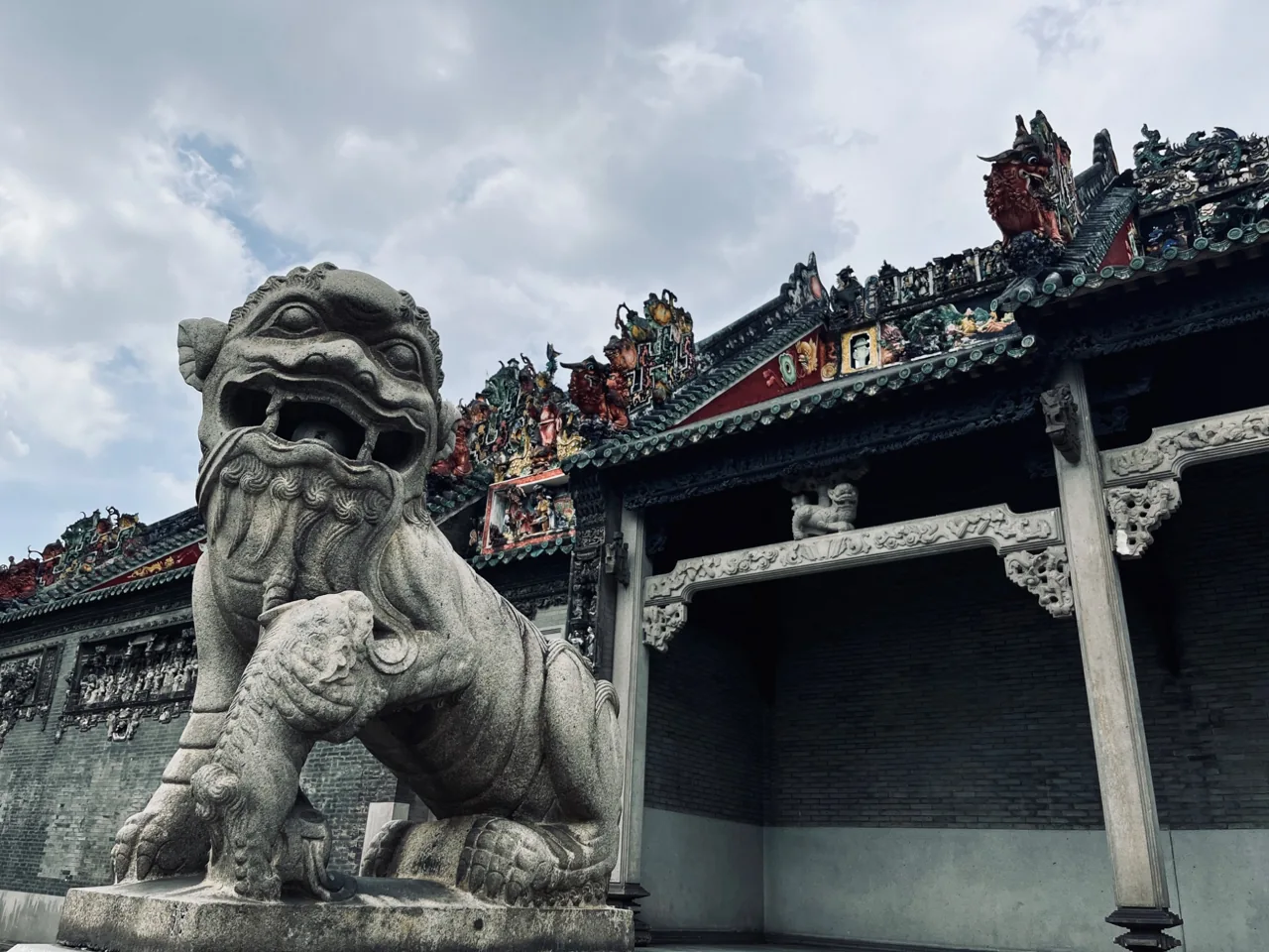 Stone lion and ornate traditional architecture