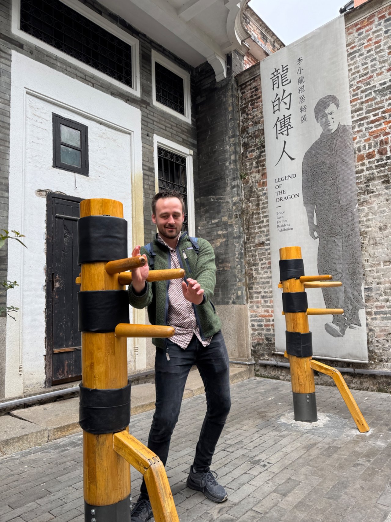 A visitor trying a wooden martial arts training dummy
