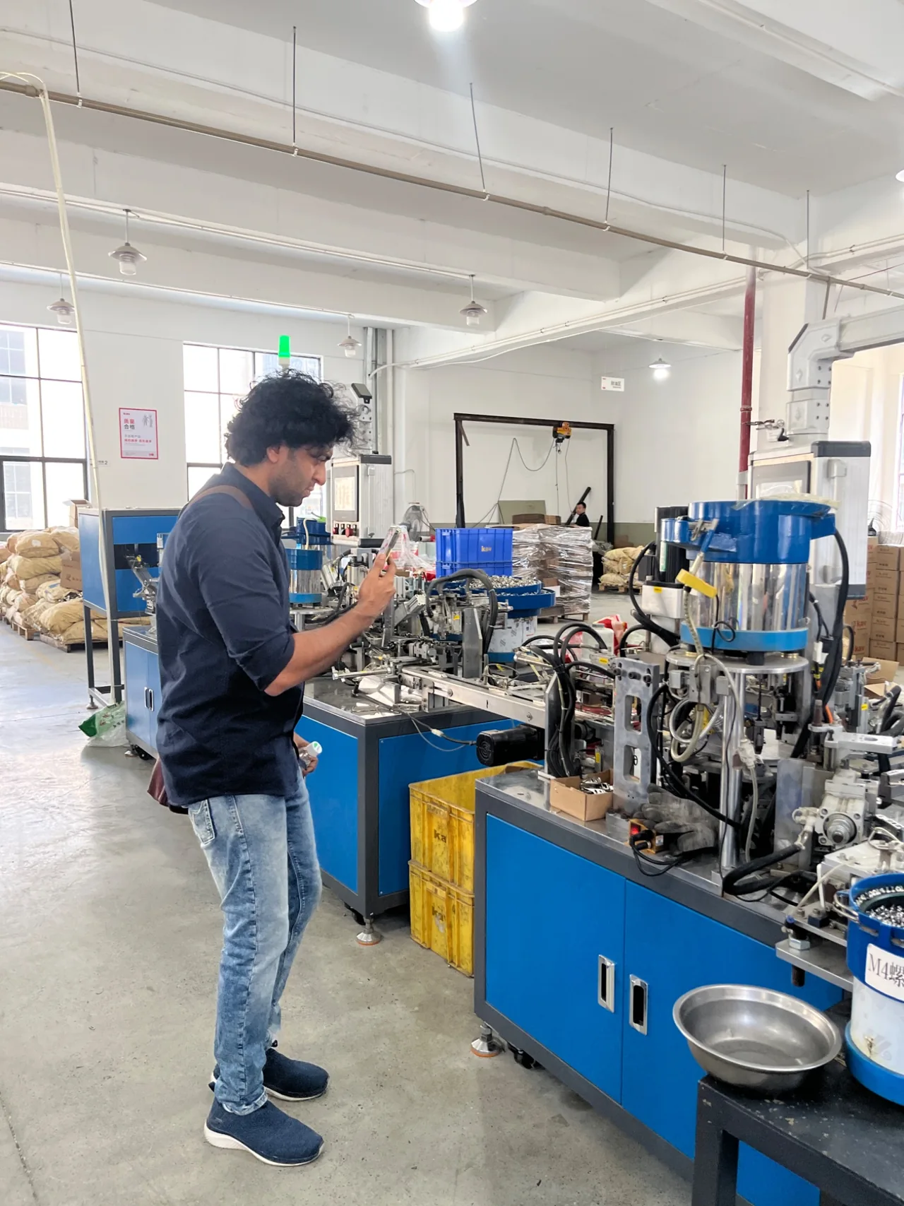 A visitor observing equipment on a production floor